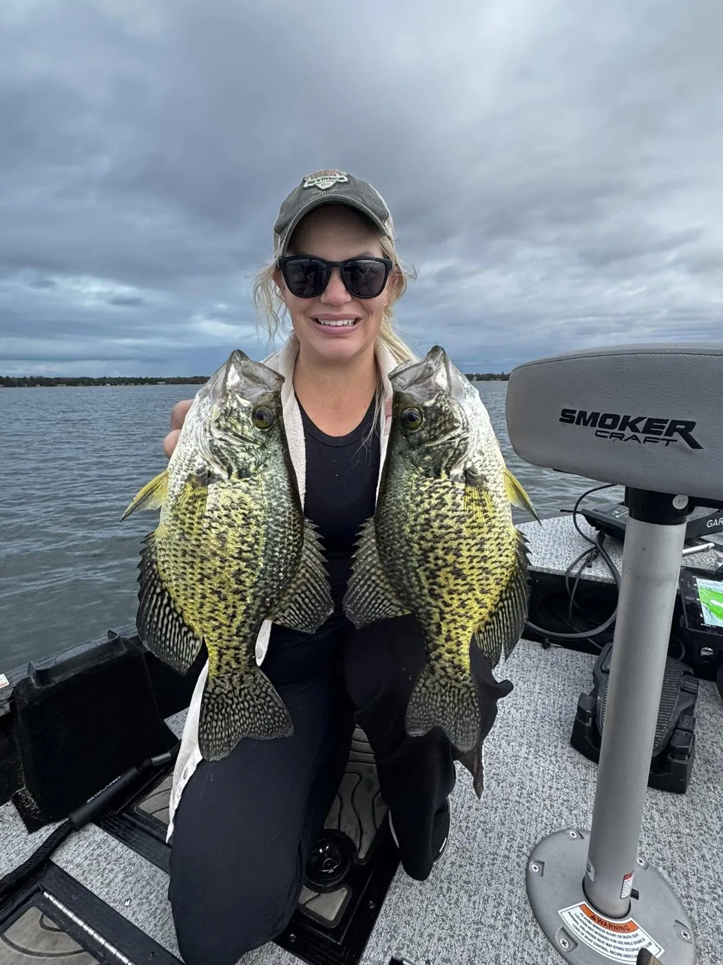Nicole holding two fall crappie on a cloudy day
