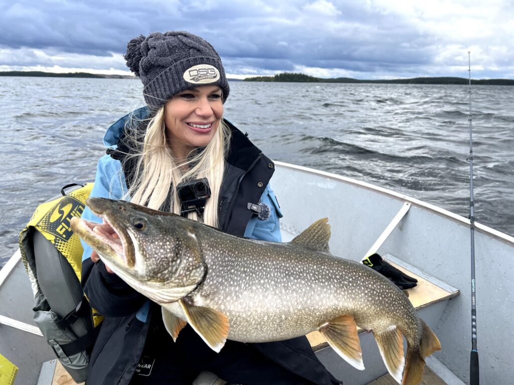Angler holding a trophy lake trout in a boat on Kamuchawie Lake