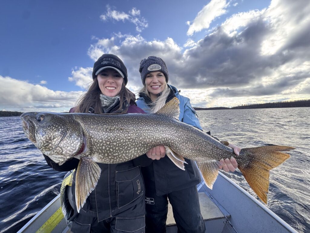 Two anglers holding a giant lake trout on Kamuchawie Lake