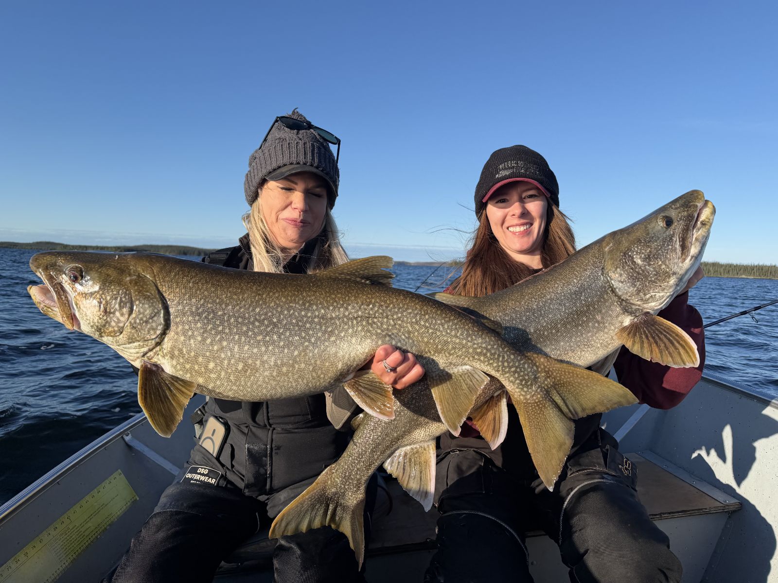 Two anglers each holding a big lake trout during a double on Kamuchawie Lake